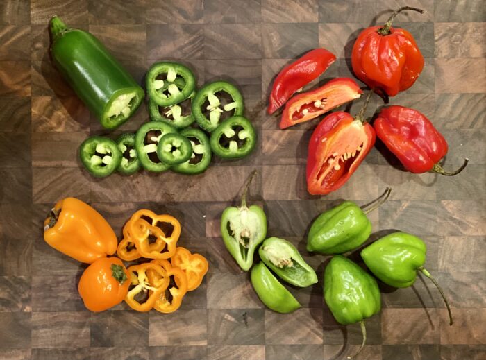 assorted fresh hot peppers on cutting board