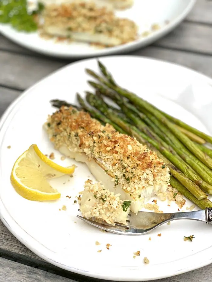 single serving of panko crusted cod with asparagus on white plate