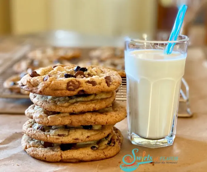 stack of Brown Butter Cookies With Espresso Chips and a glass of mik with a straw
