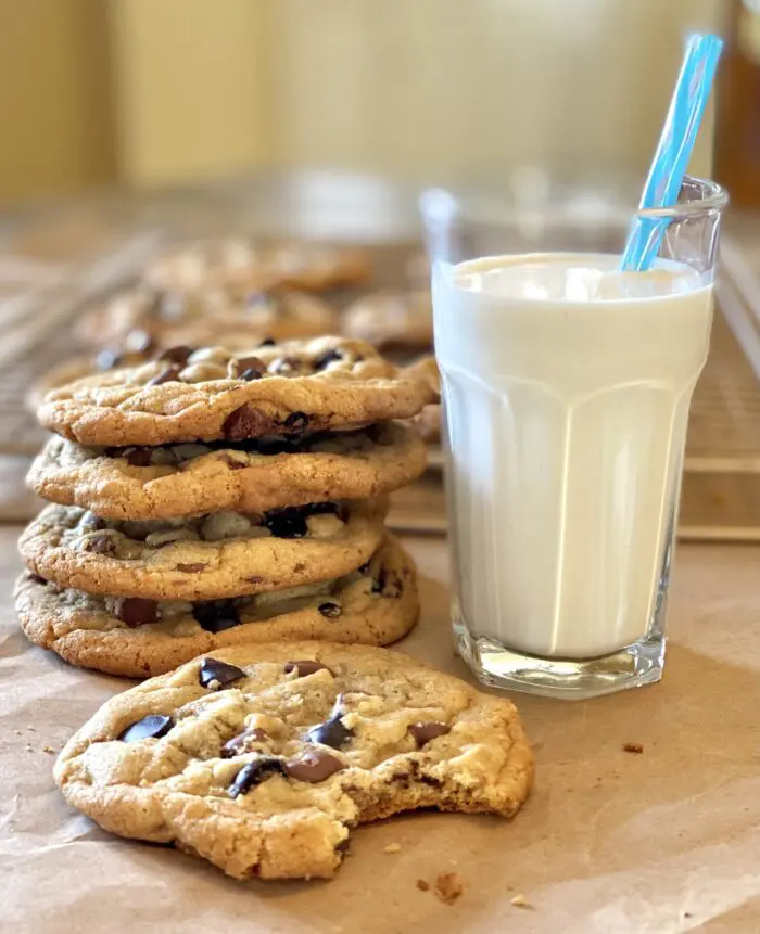 Stack of Brown Butter Cookies With Espresso chips and a glass of milk with a straw