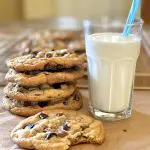stack of brown butter cookies with glass of milk and a straw