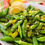 sugar snap peas recipe with lemon and fresh mint in a white bowl