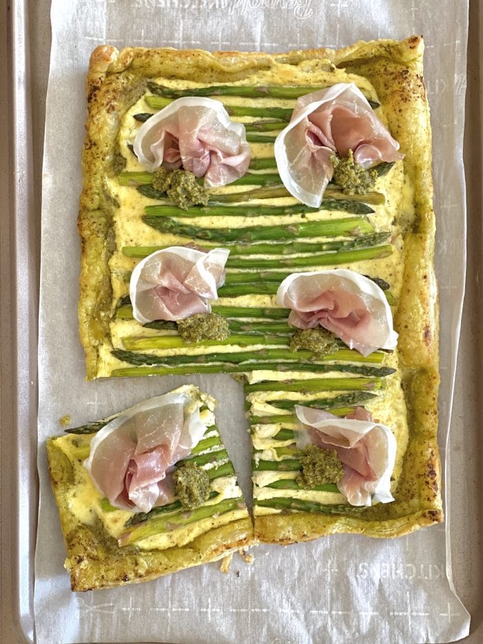 overhead photo of an asparagus tart with a piece cut