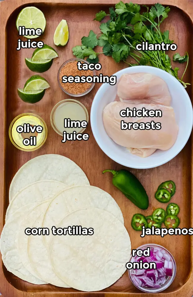 ingredients for chicken street tacos on a wooden board