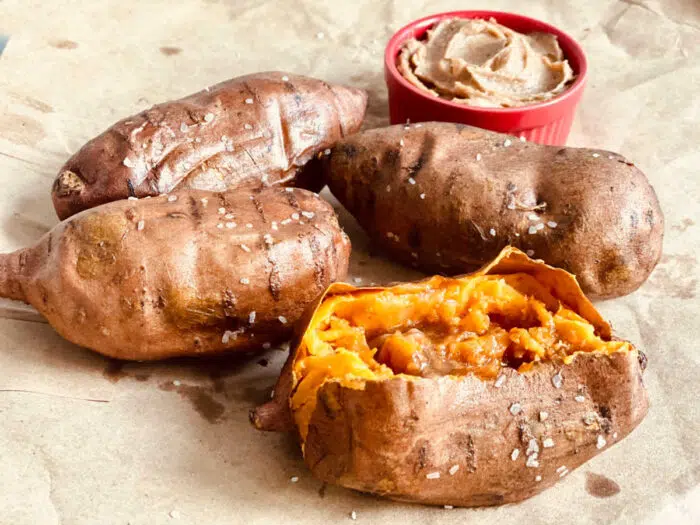 four air fryer sweet potatoes with brown sugar cinnamon butter on parchment paper