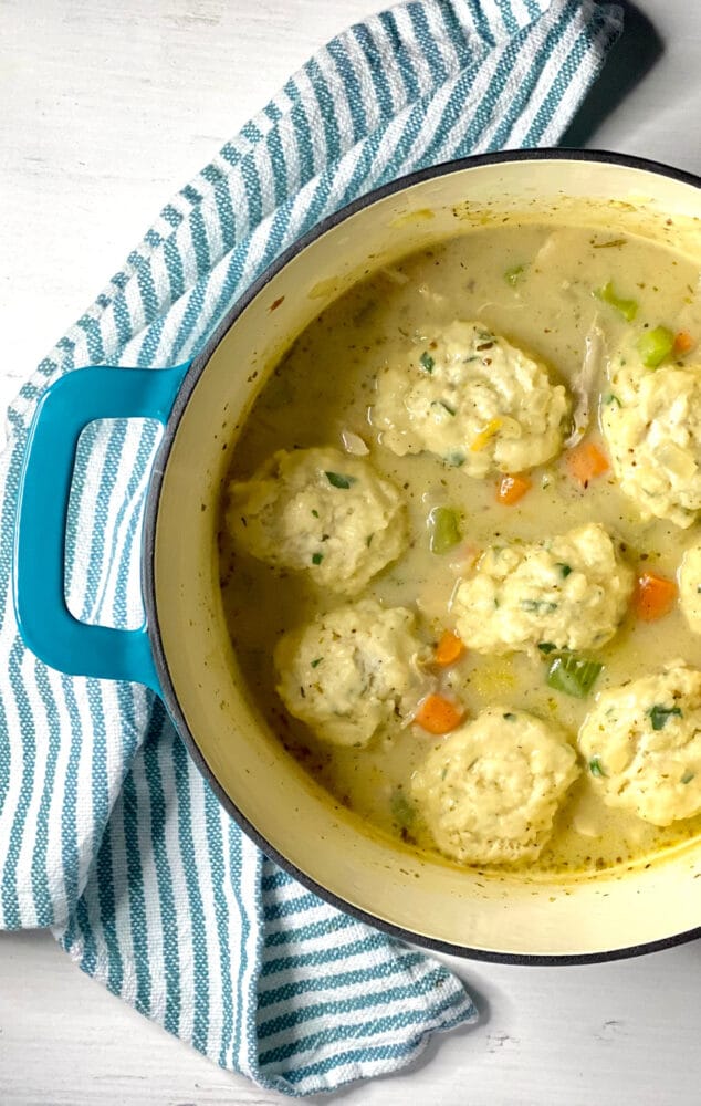 chicken with dumplings in a blue pot with a napkin