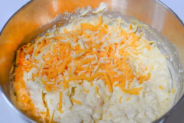 adding corn muffin mix and shredded cheese