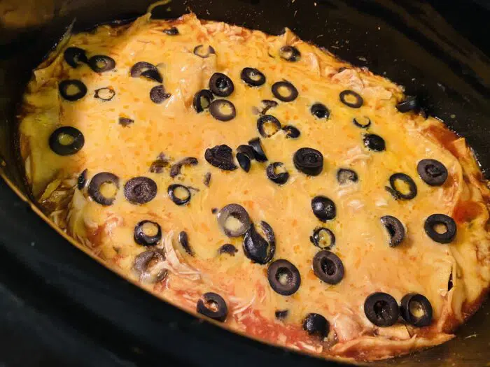 chicken enchilada casserole with melted cheese with olives