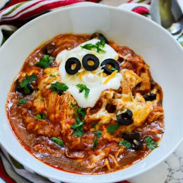 bowl of slow cooker enchilada chicken with sour cream and cilantro