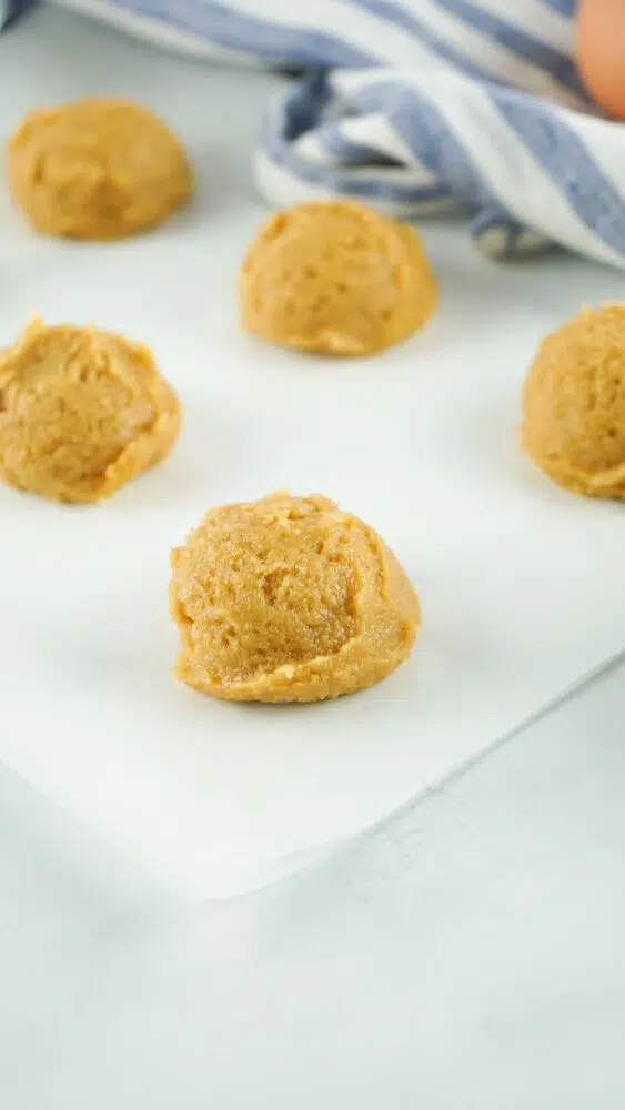 scoops of peanut butter cookie dough on parchment paper