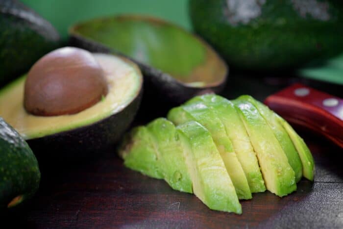 avocado slices and half an avocado with a pit