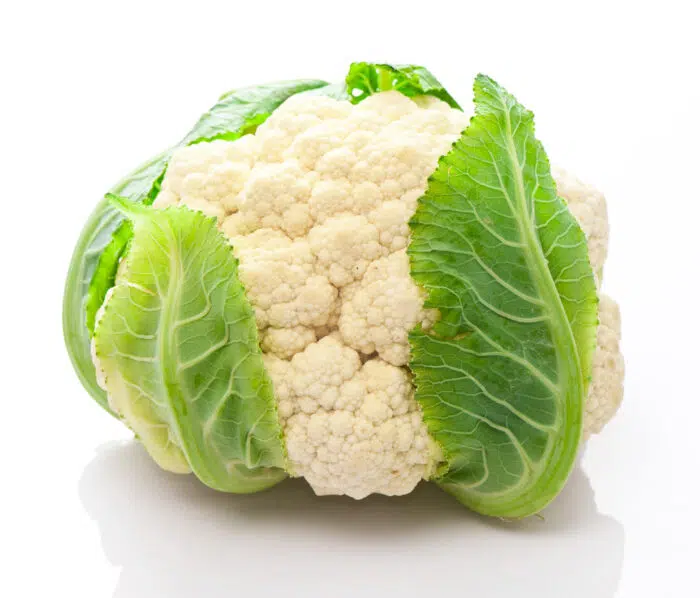 head of cauliflower with green leaves