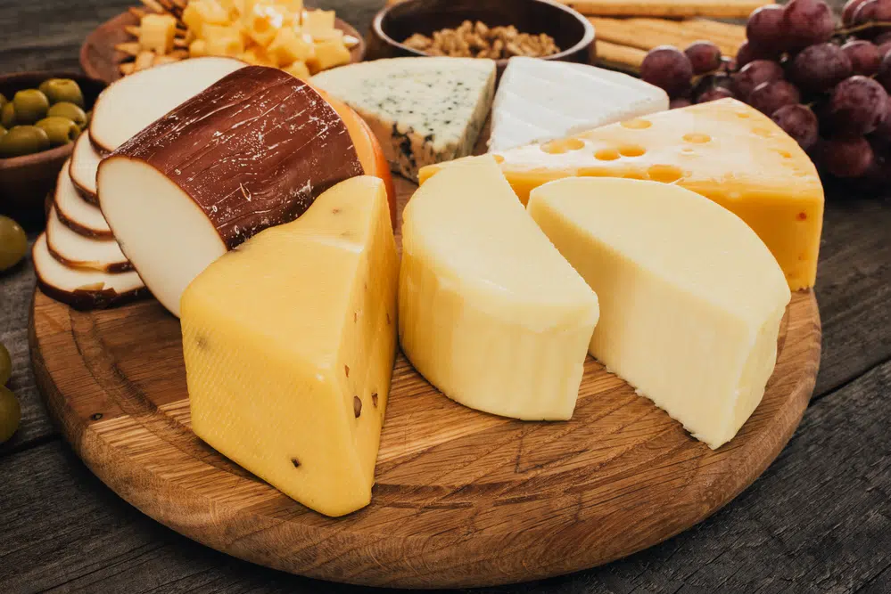assorted cheeses on a wooden board