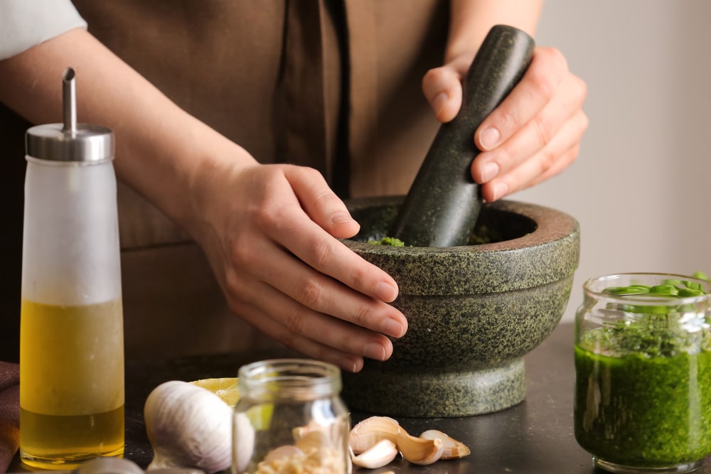 making pesto with a mortar and pestle