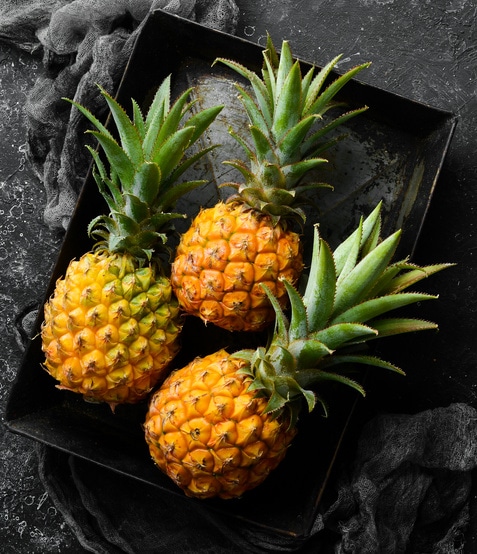 three baby pineapples