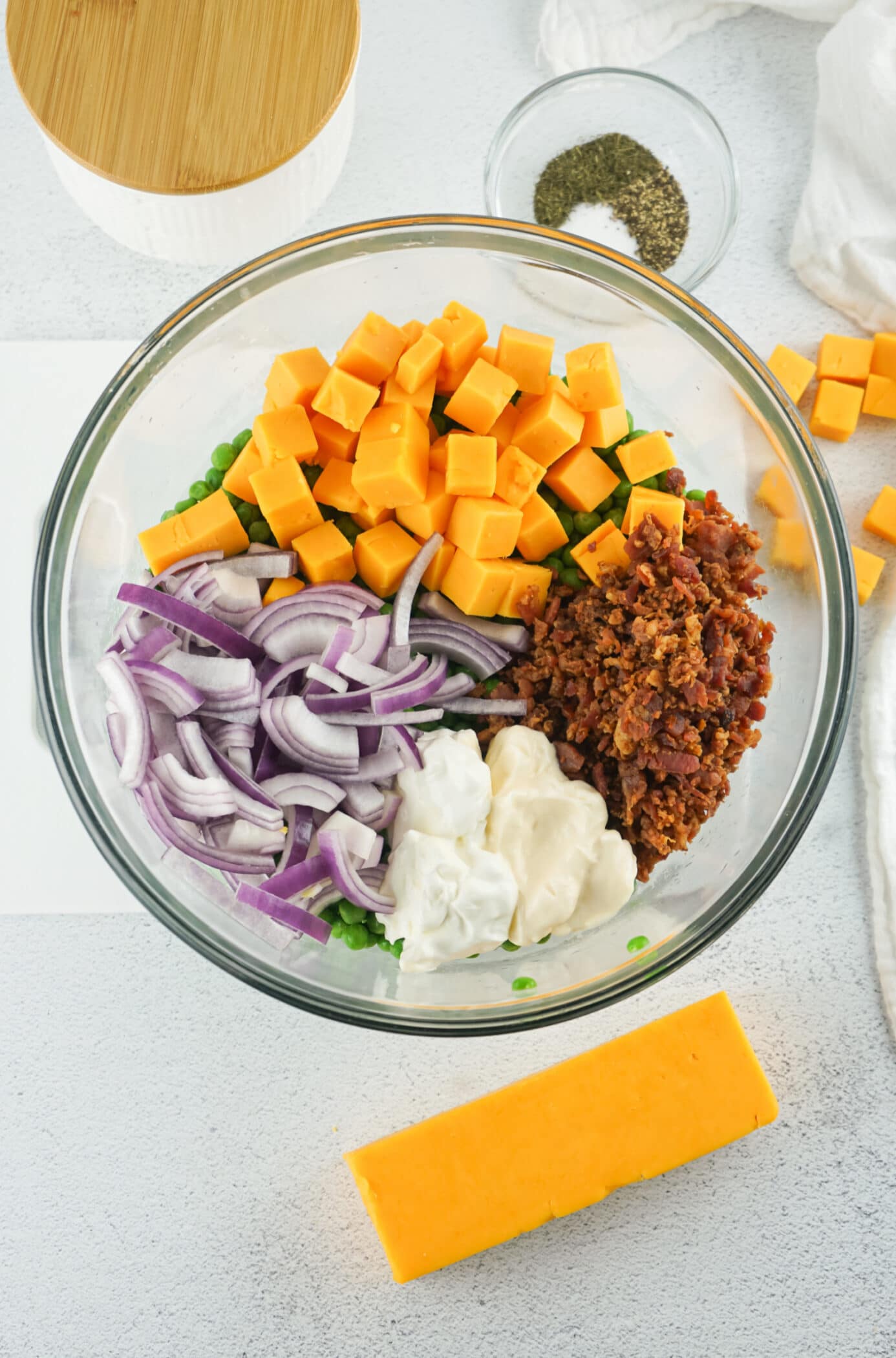 combining ingredients in a bowl for pea salad