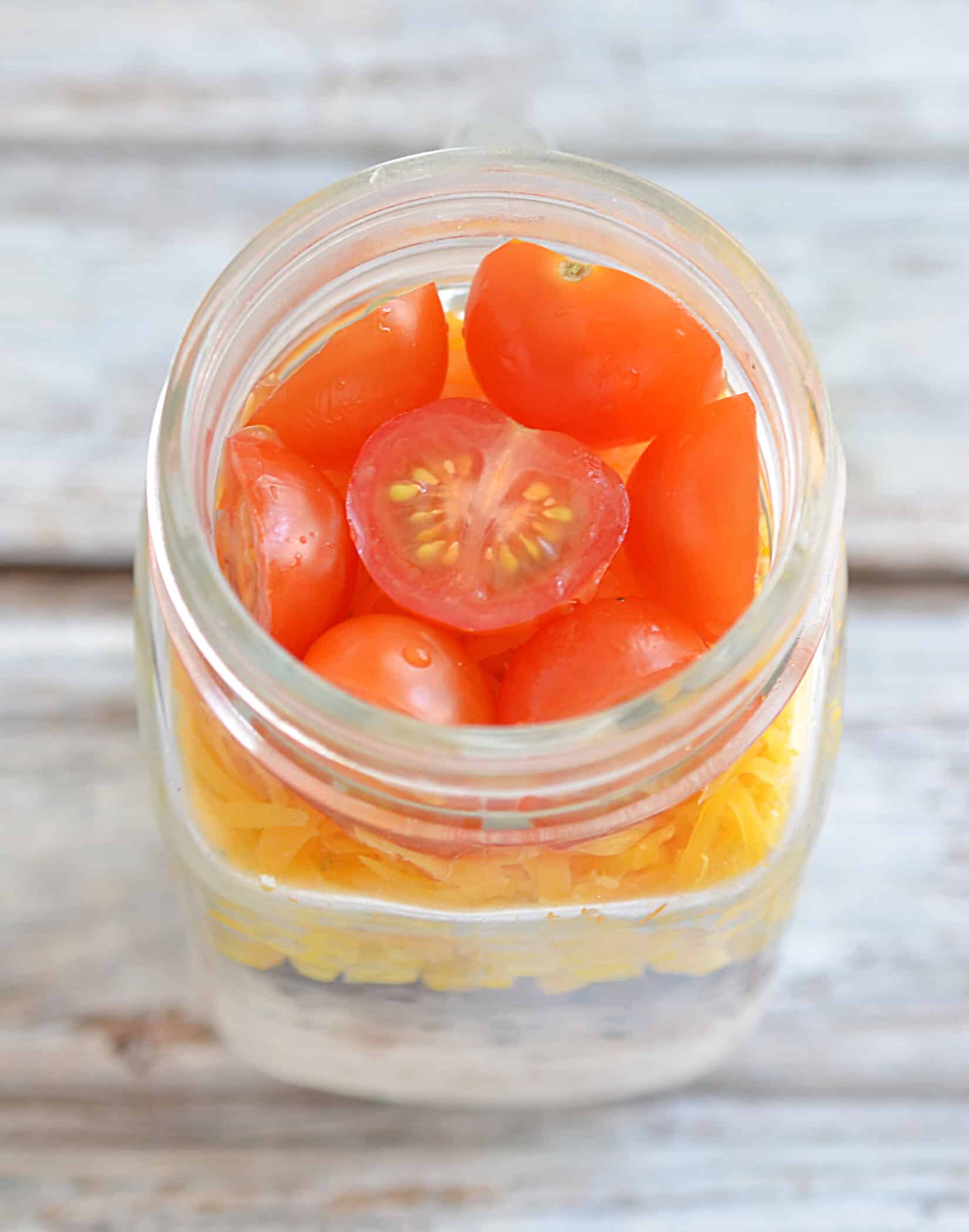 layer of tomatoes in a mason jar