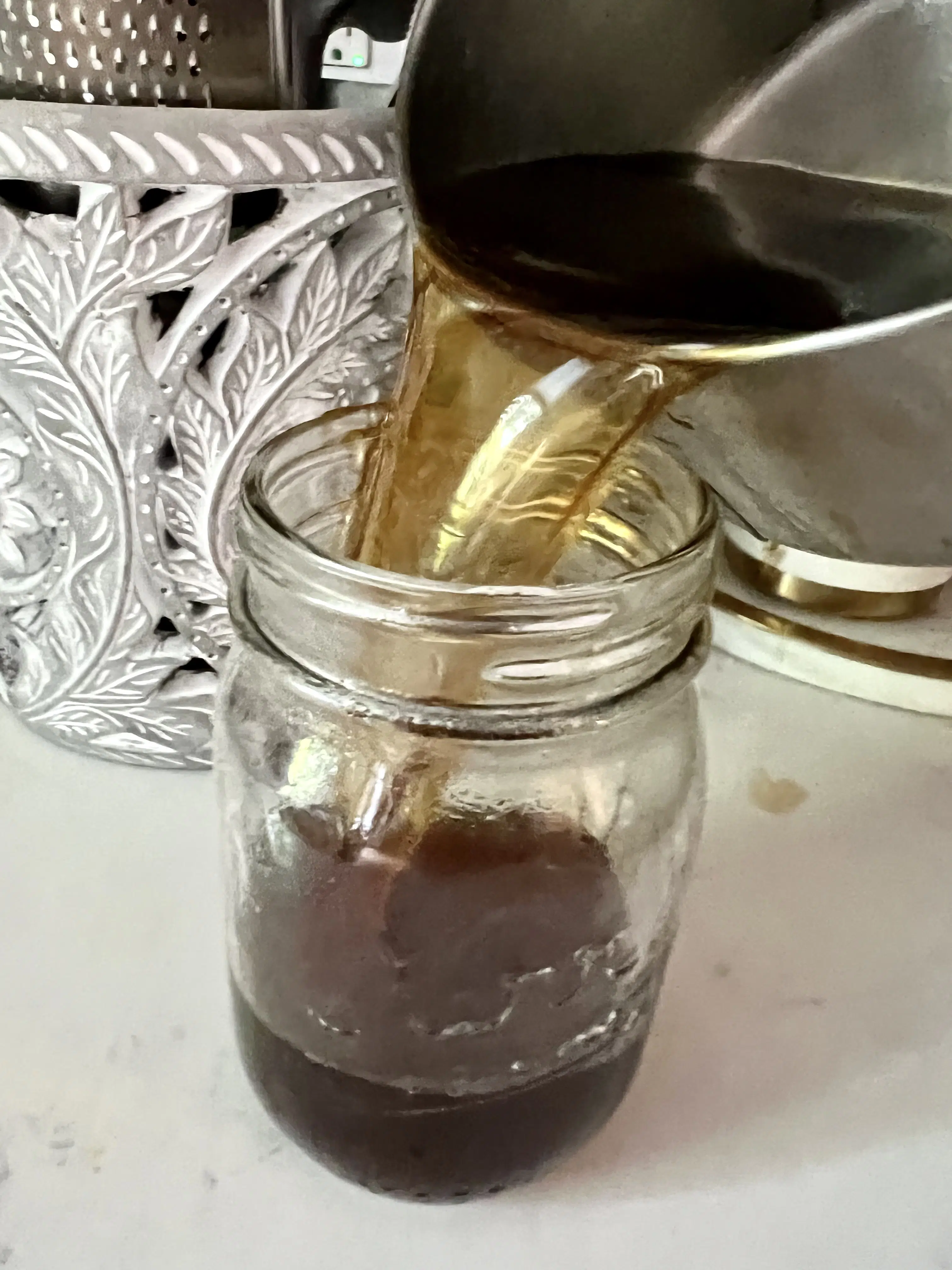 pouring brown sugar syrup into a mason jar