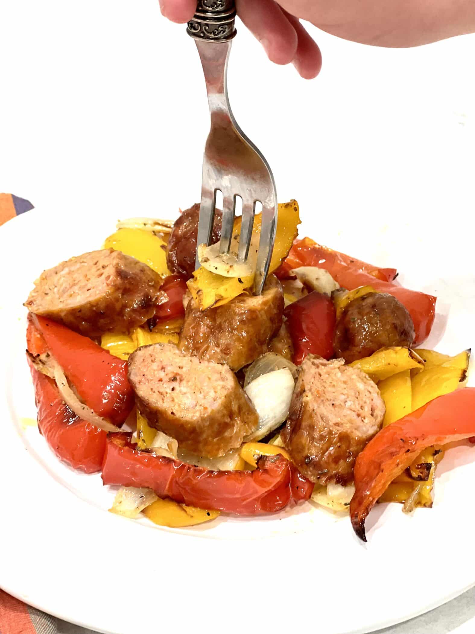 sliced sausages and peppers on a dish with a fork