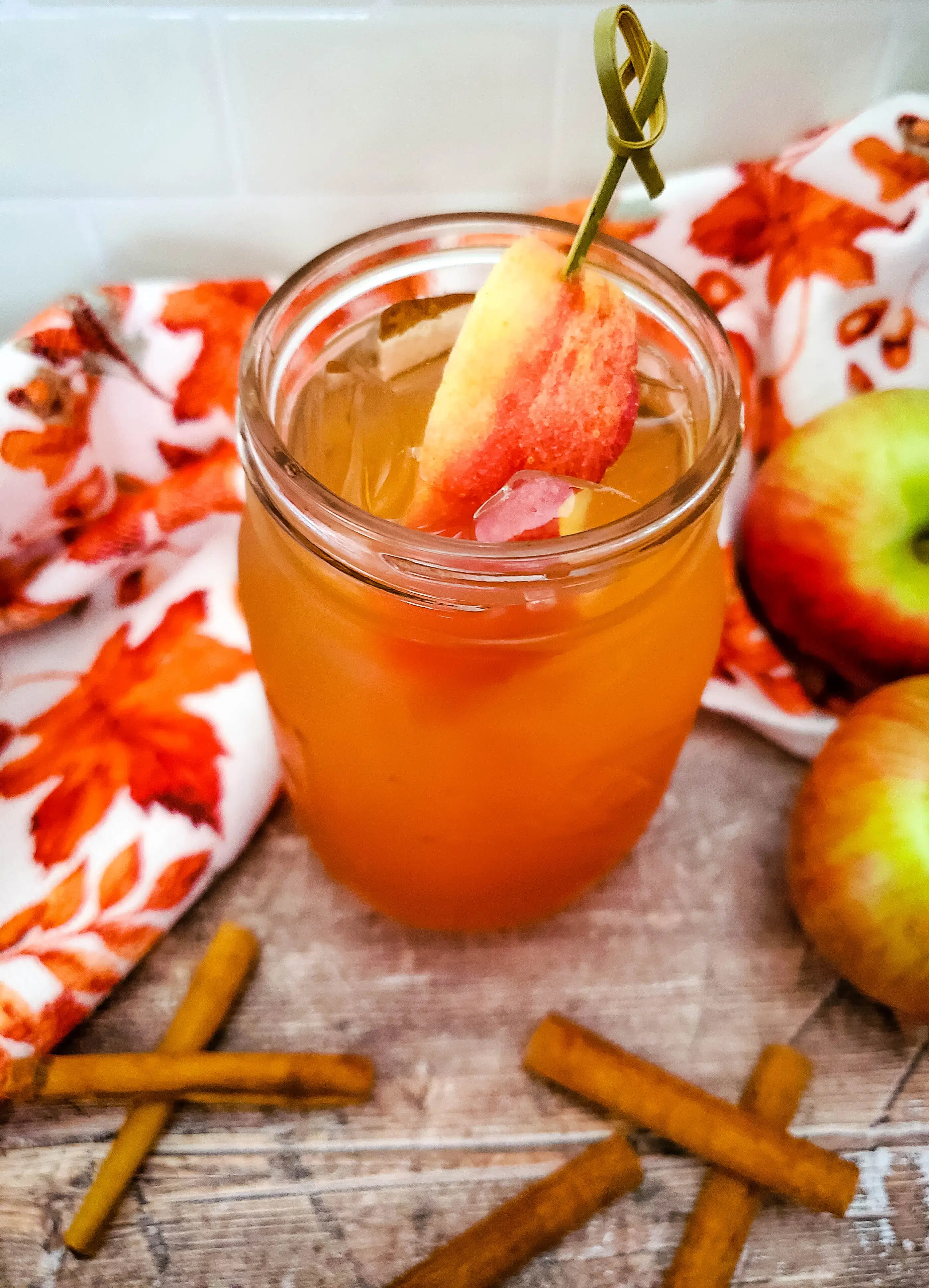 apple cider cocktail with apple slice and cinnamon sticks