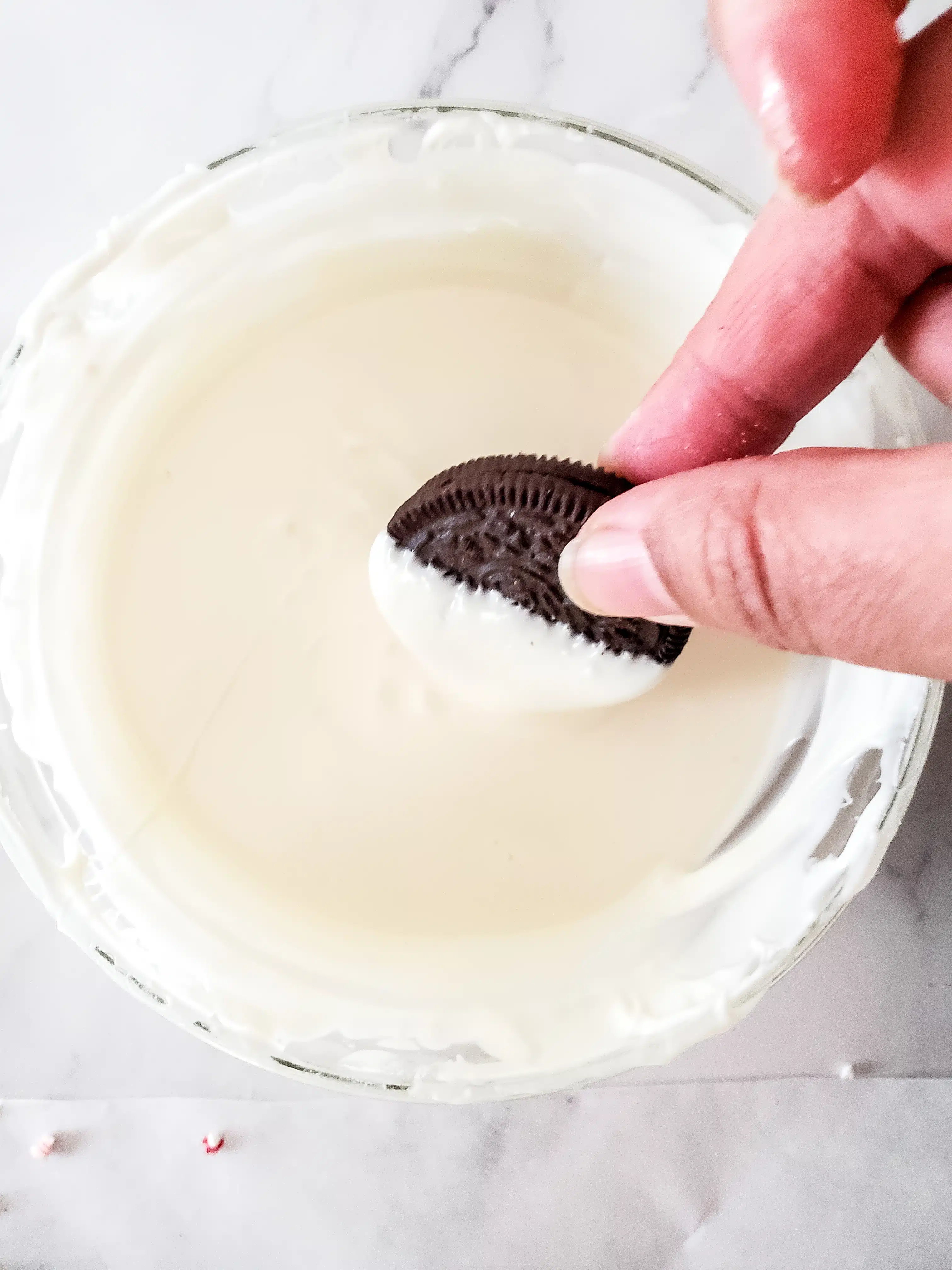 dipping oreo into melted white chocolate