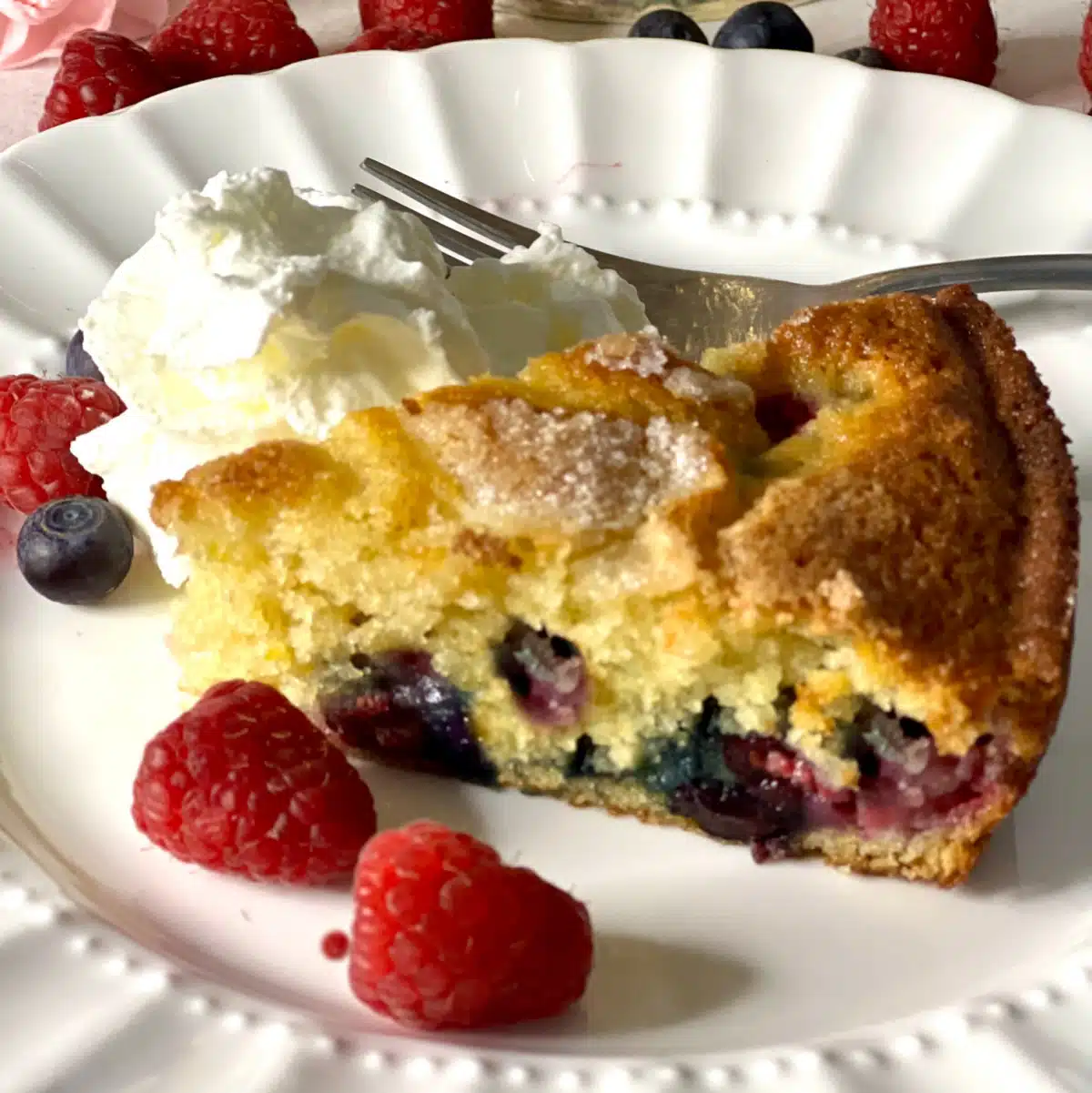 slice of vanilla berry cake with fresh berries