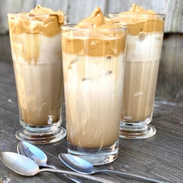 three glasses of iced dalgona coffee with spoons