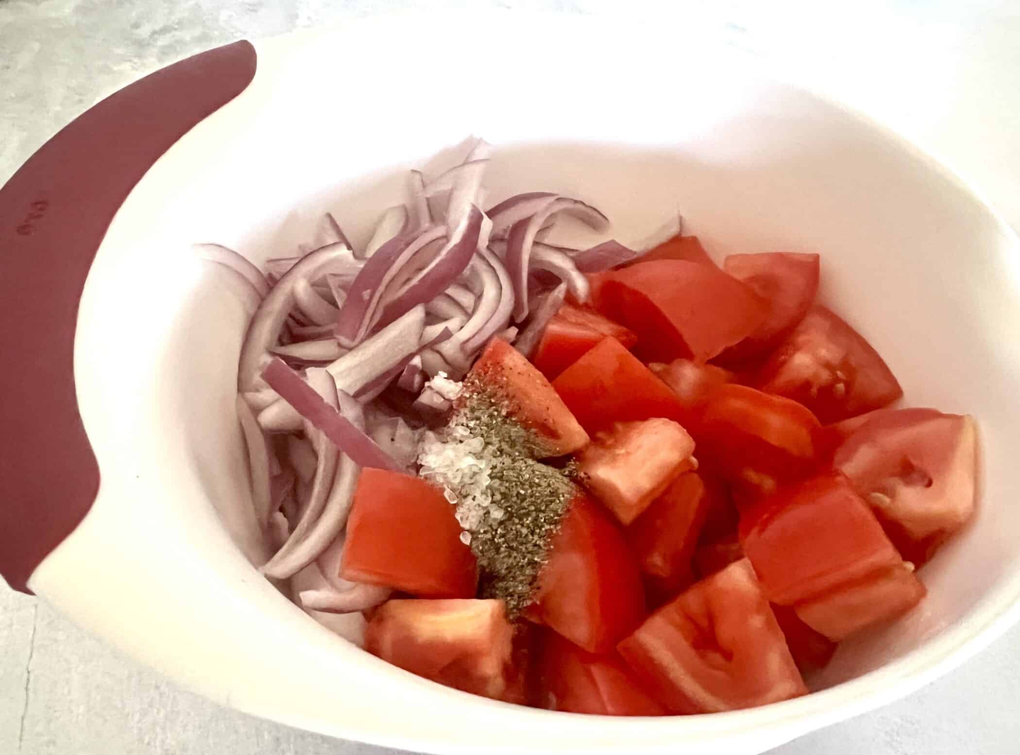 ingredients in a bowl for tomato salad