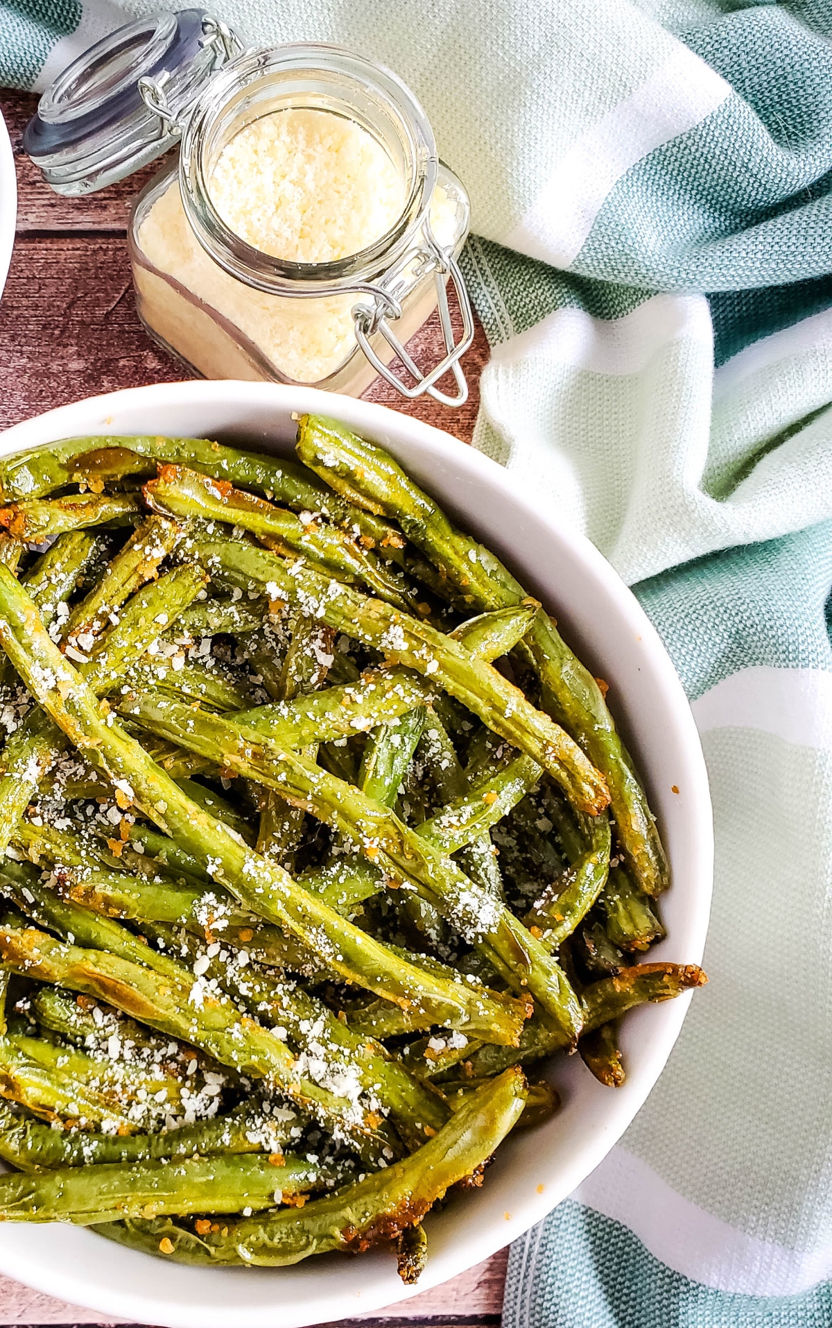 bowl of green beans and jar of parmesan cheese