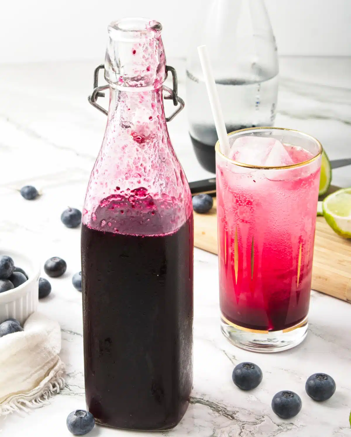 blueberry syrup in a bottle wwith glass and fresh blueberries