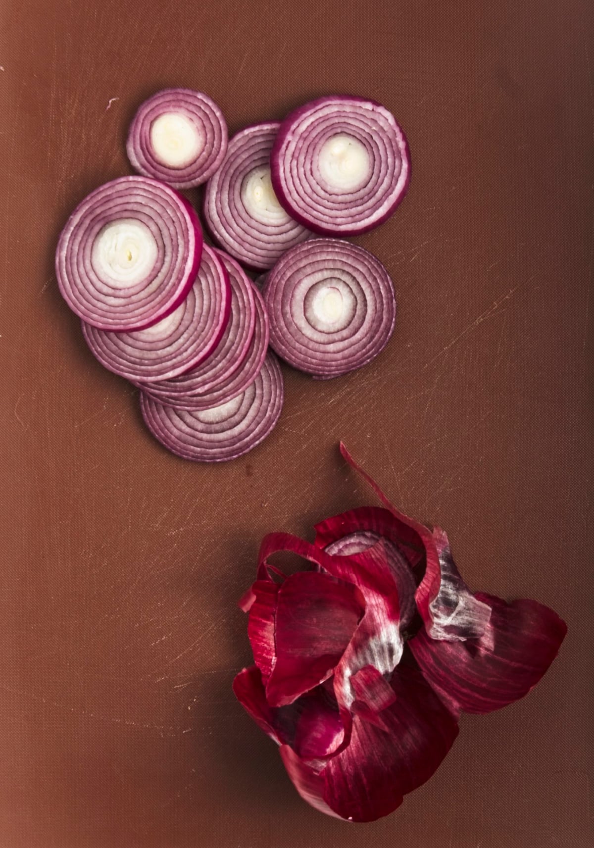 sliced red onions on a wooden board