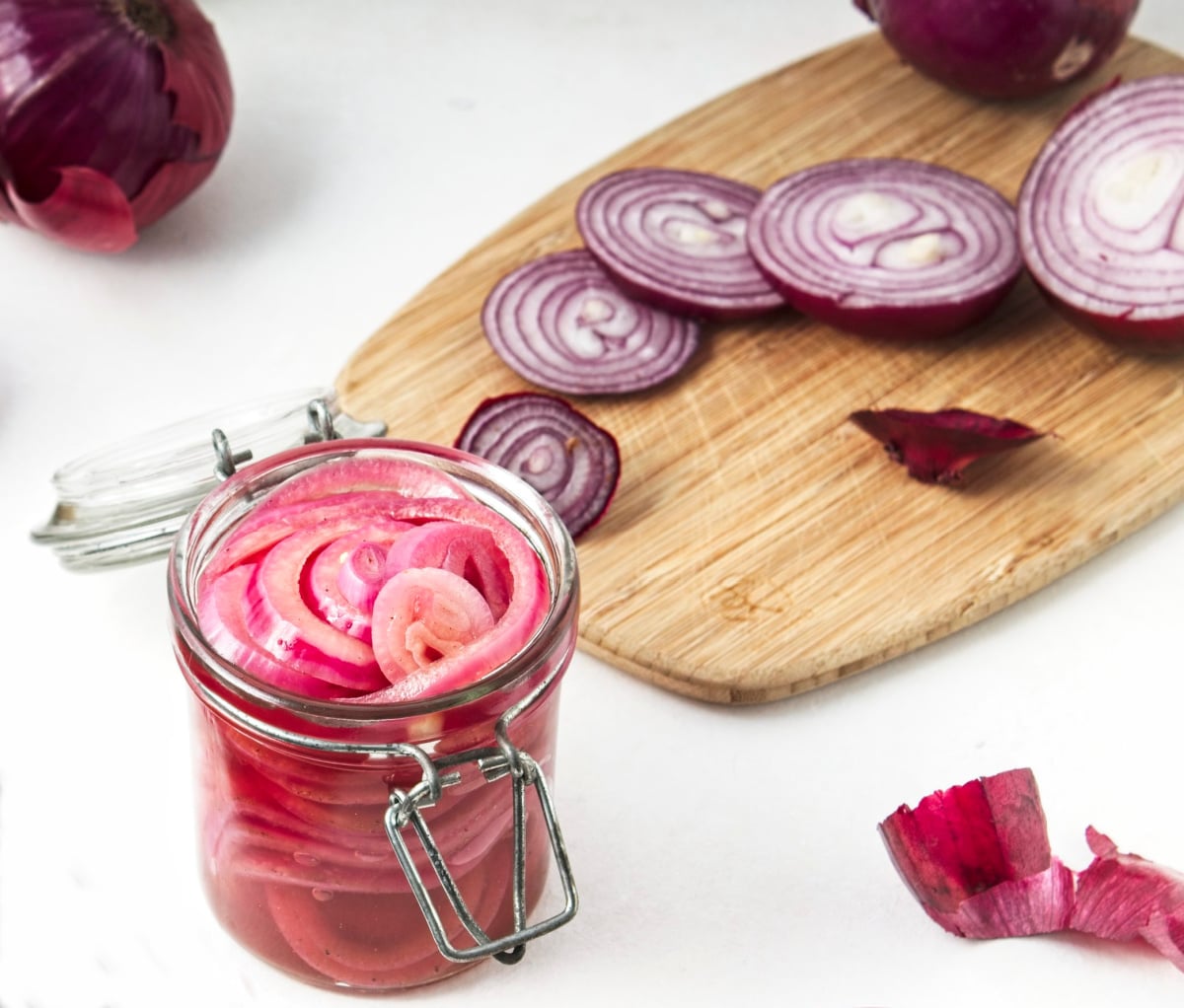 pickled onions with sliced onions on a cutting board