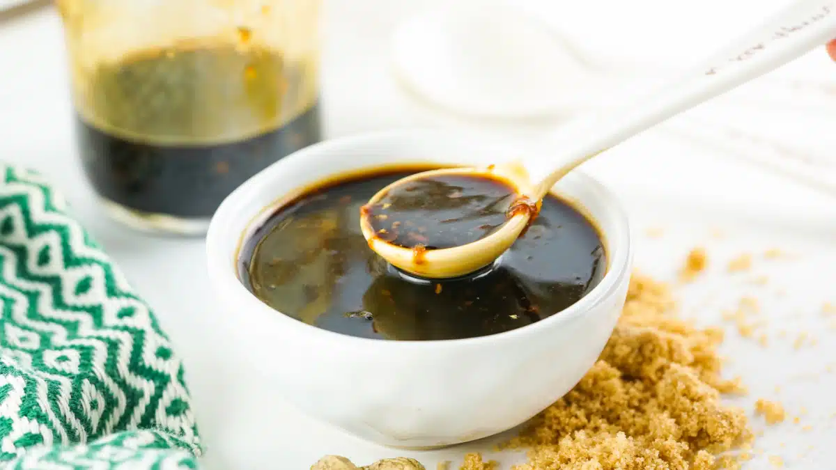 homemade teriyaki sauce in a white bowl and on spoon