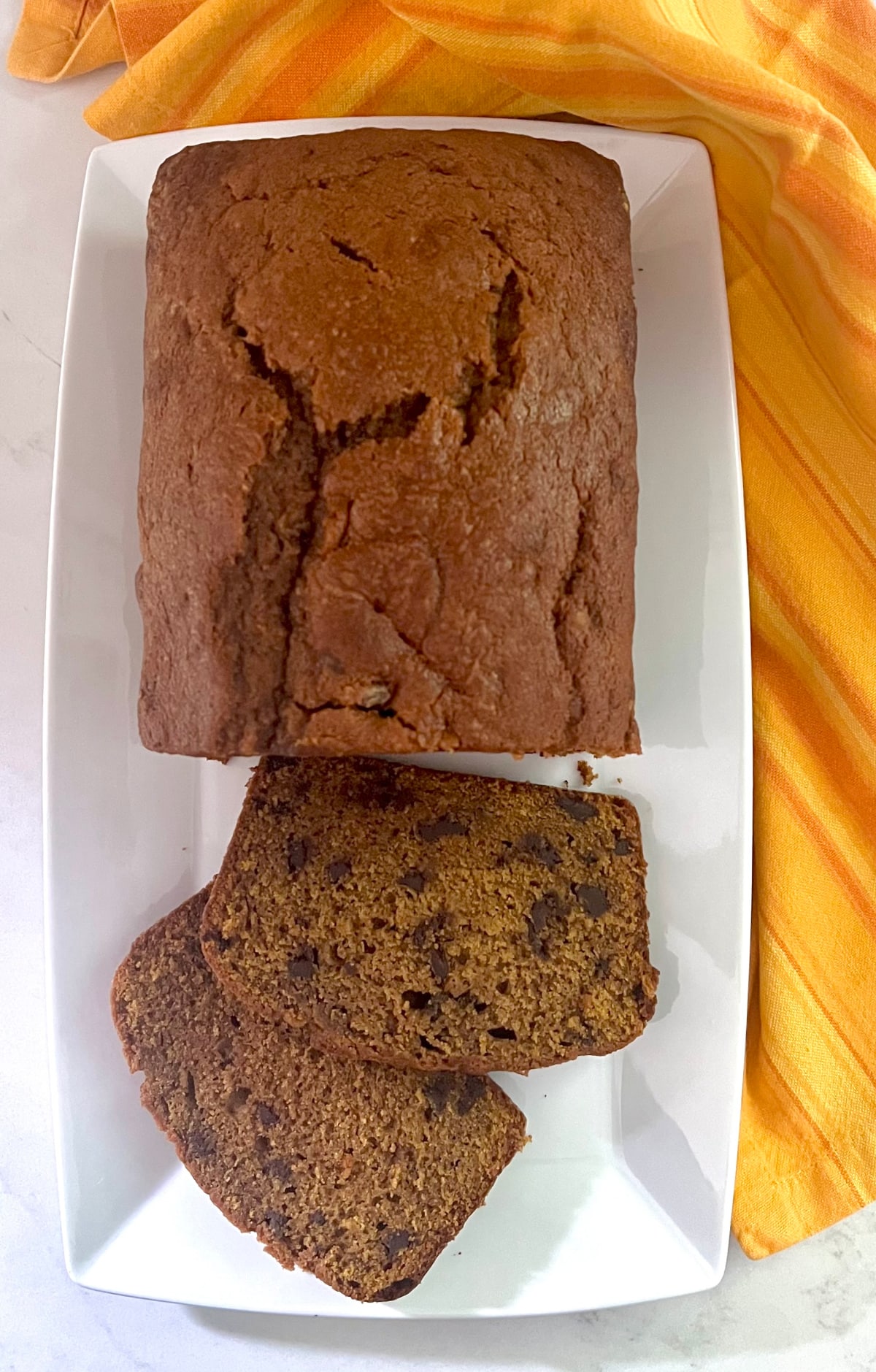 overhead of chocolate chip pumpkin bread on a platter with slices