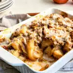 apple cinnamon roll crumble in baking dish with scoop out