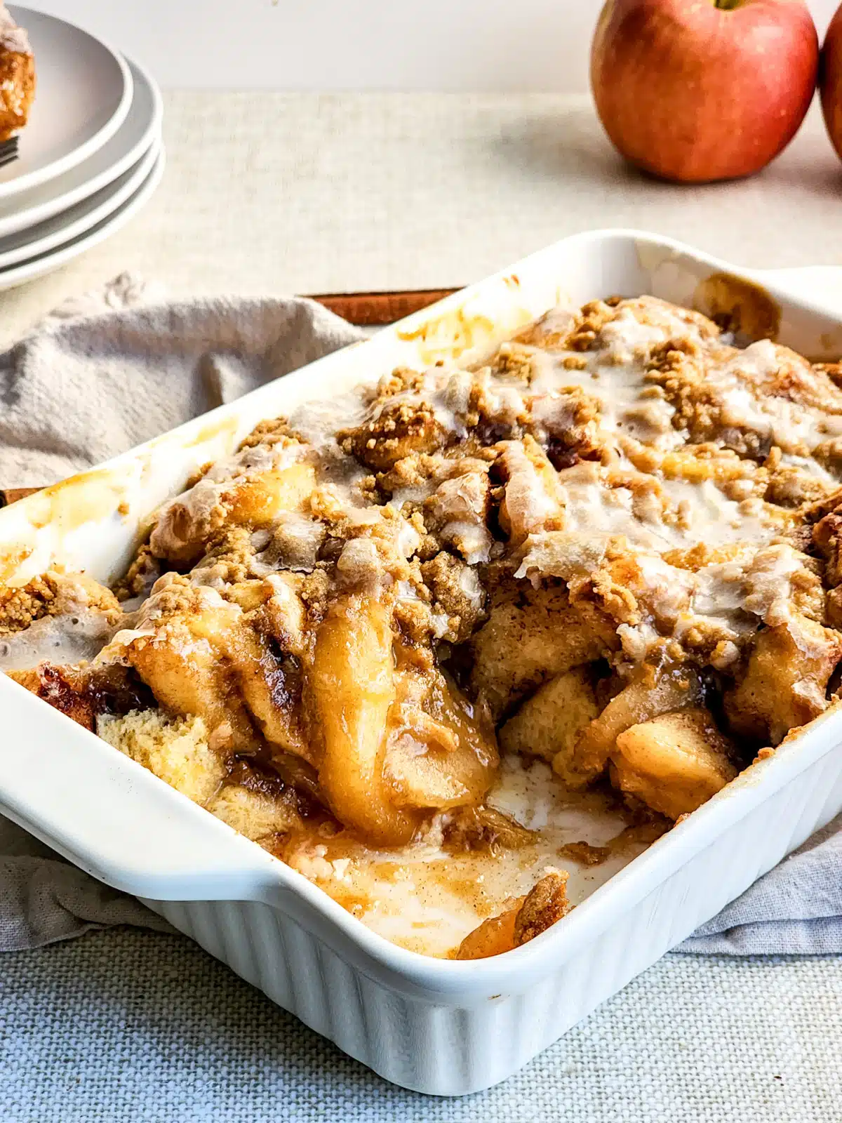 apple cinnamon roll crumble in baking dish with scoop out