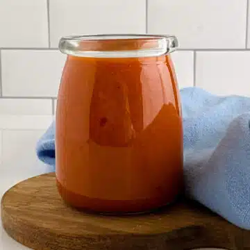 jar of homemade buffalo sauce with blue napkin