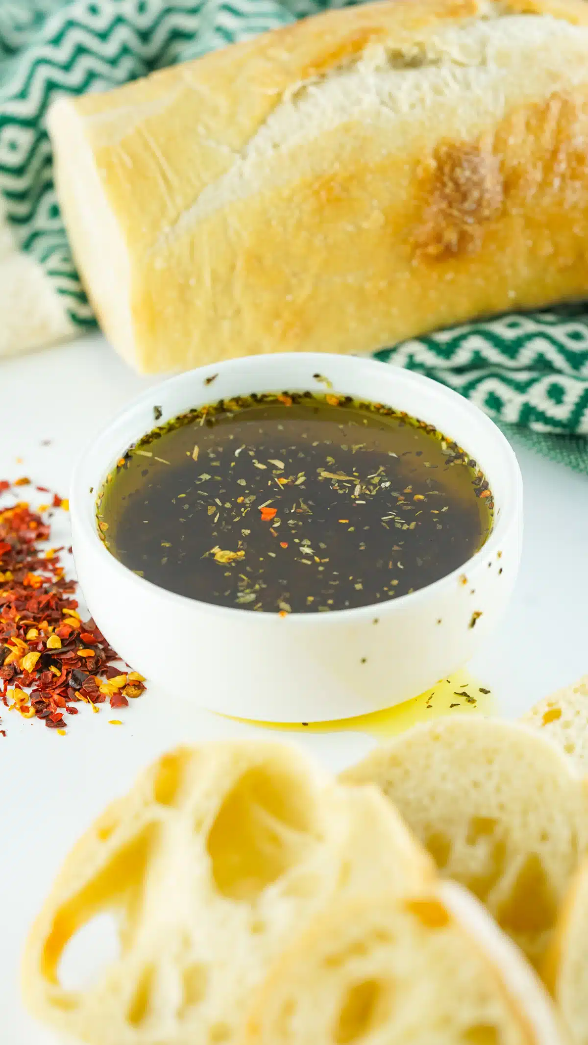 bowl of olive oil dipping sauce with loaf of bread
