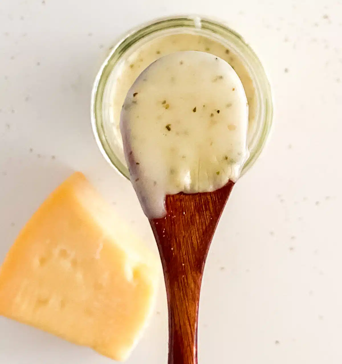 copycat garlic cream sauce on wooden spoon