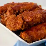 Transfer the chicken tenders as they’re cooked to a wire rack over a paper towel-lined baking sheet. Mix together the glaze ingredients and brush it over the top of the hot tenders and serve. on a platter with blue napkin