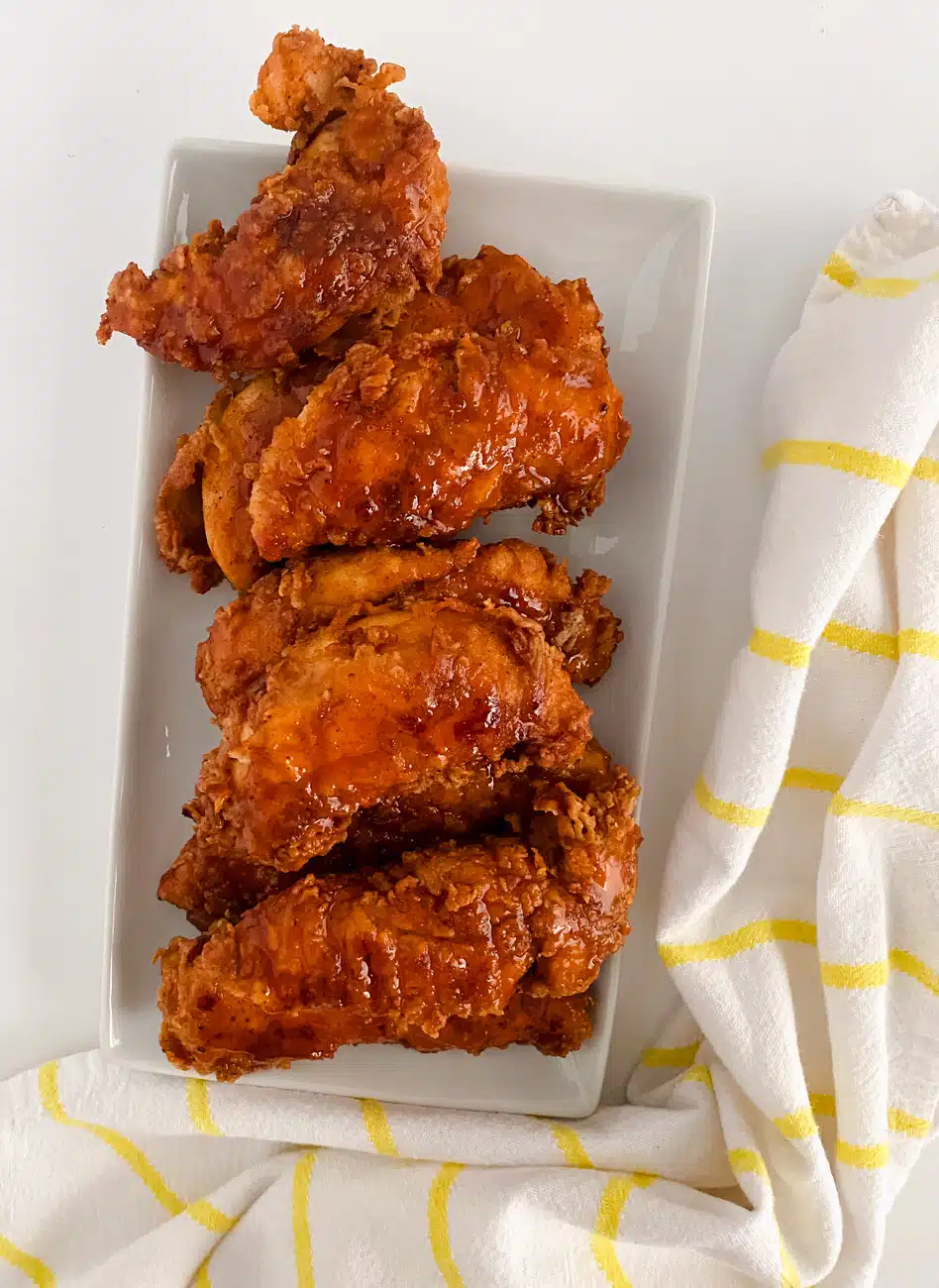Transfer the chicken tenders as they’re cooked to a wire rack over a paper towel-lined baking sheet. Mix together the glaze ingredients and brush it over the top of the hot tenders and serve.