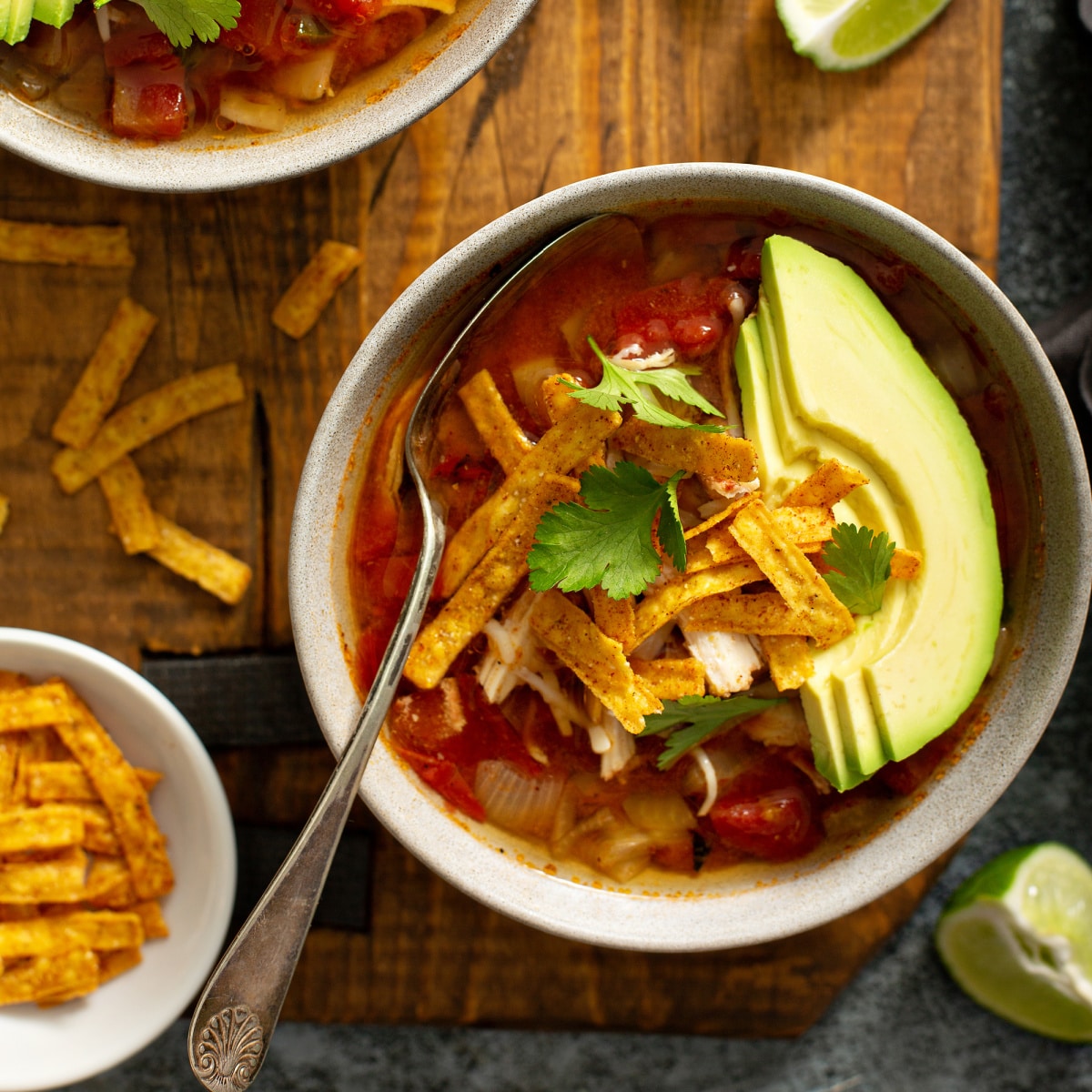 bowl of taco soup with sliced avocado and toppings