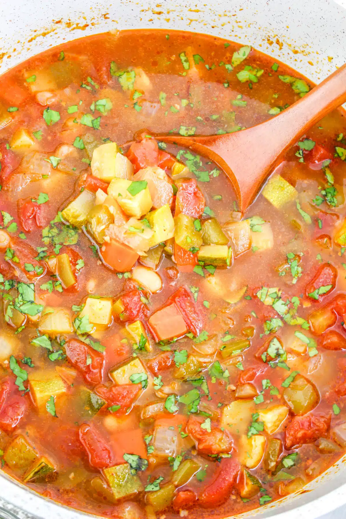 overhead photo of white bean chili with a wooden spoon