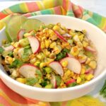 charred corn saladin a white bowl with colorful napkin