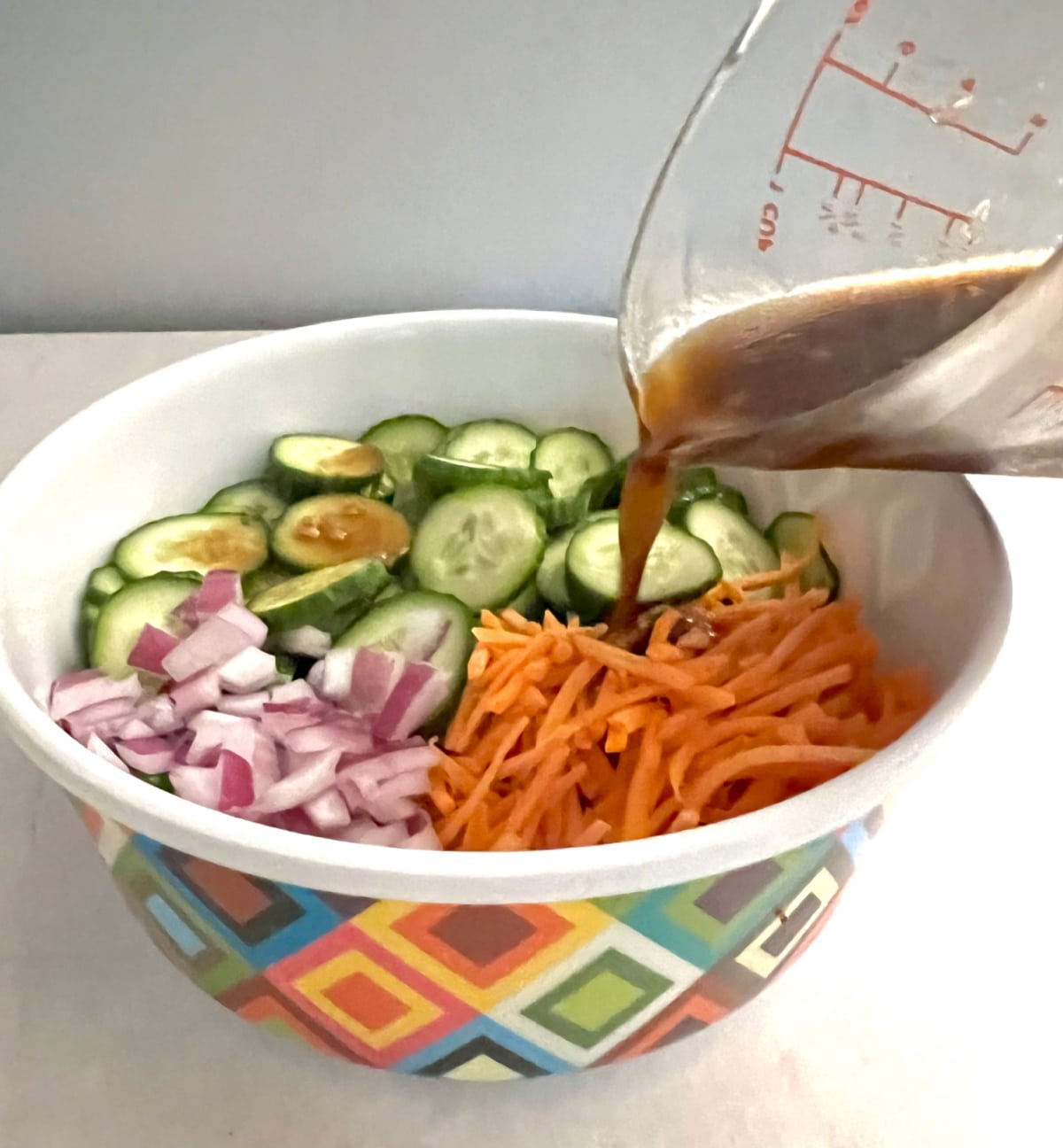 adding dressing to the cucumber mixture
