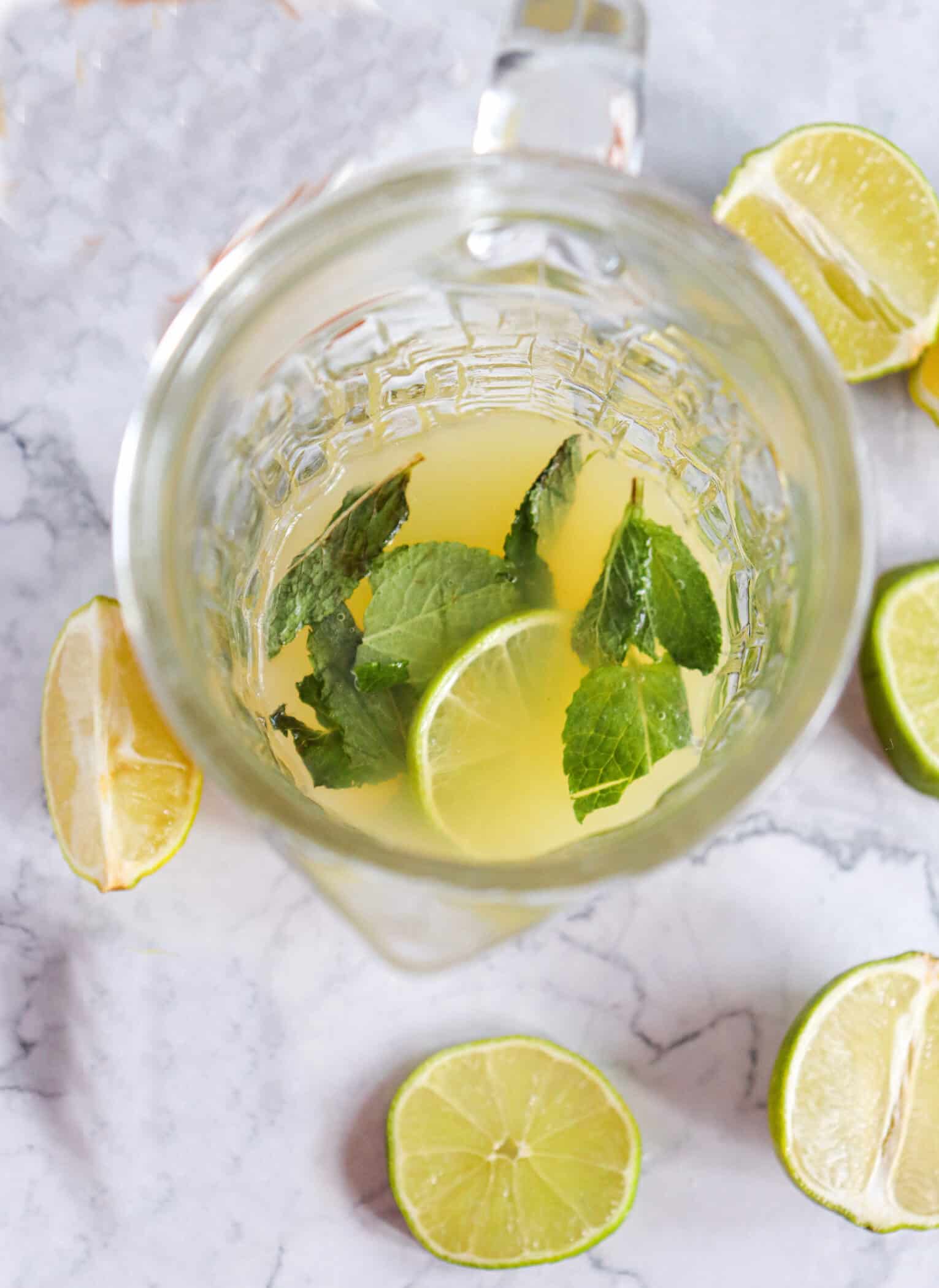 adding limes and mint to mojito