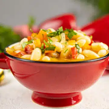 butter bean stew in a red bowl with handles