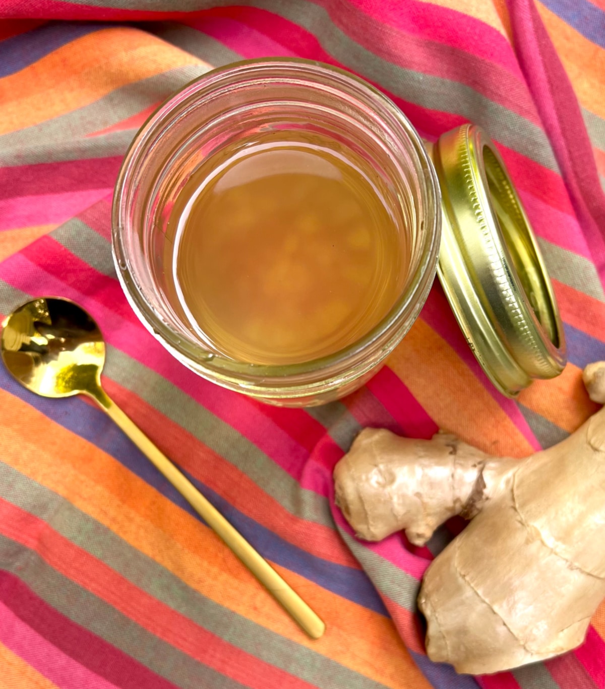 overhead of ginger syrup in a mason jar with colorful napkin