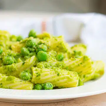 pesto pasta with peas in a white dish