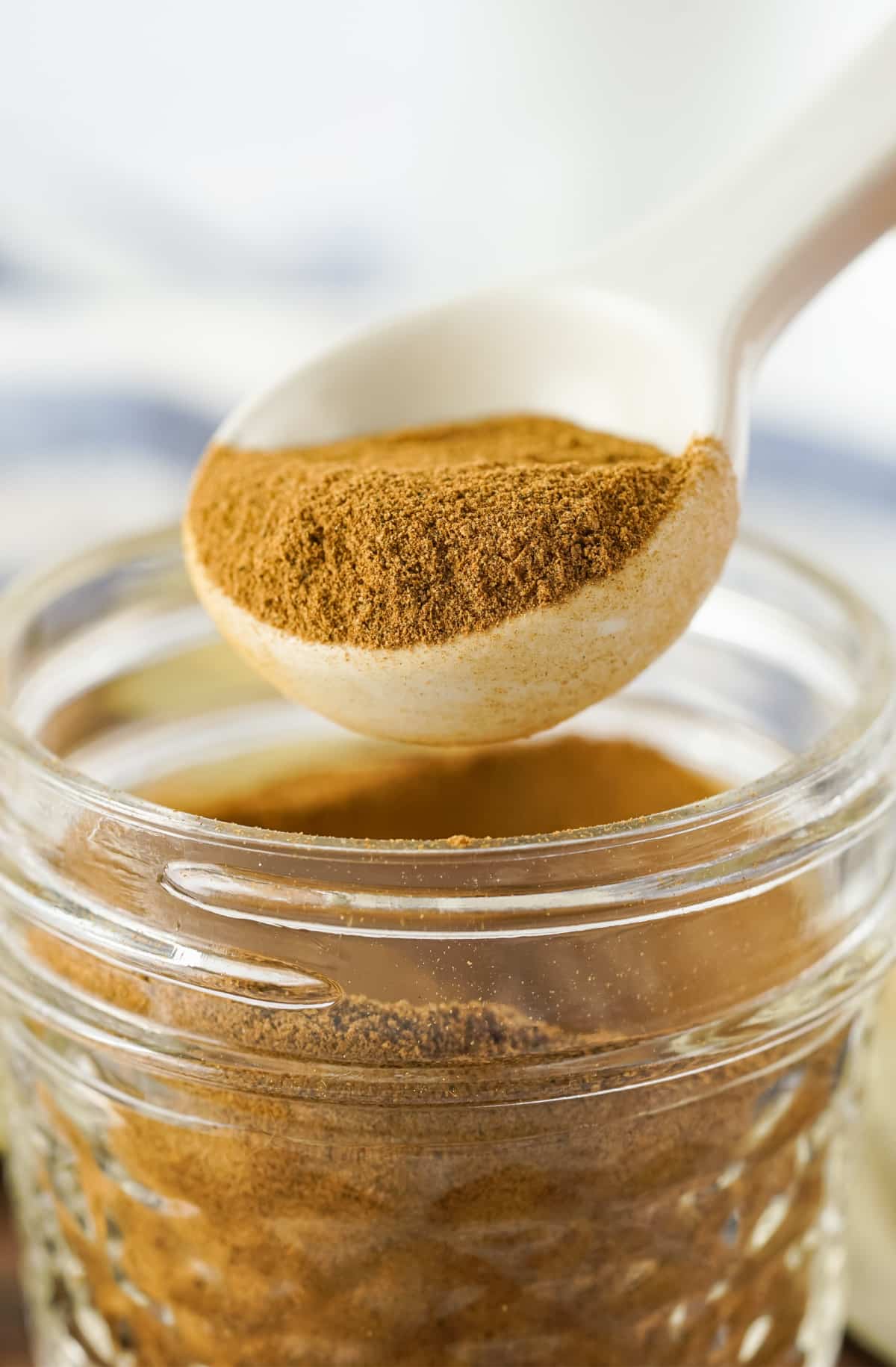 apple pie seasoning in a clear jar with a spoonful